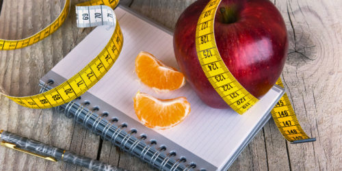 Measuring tape wrapped around a apple weight loss photo